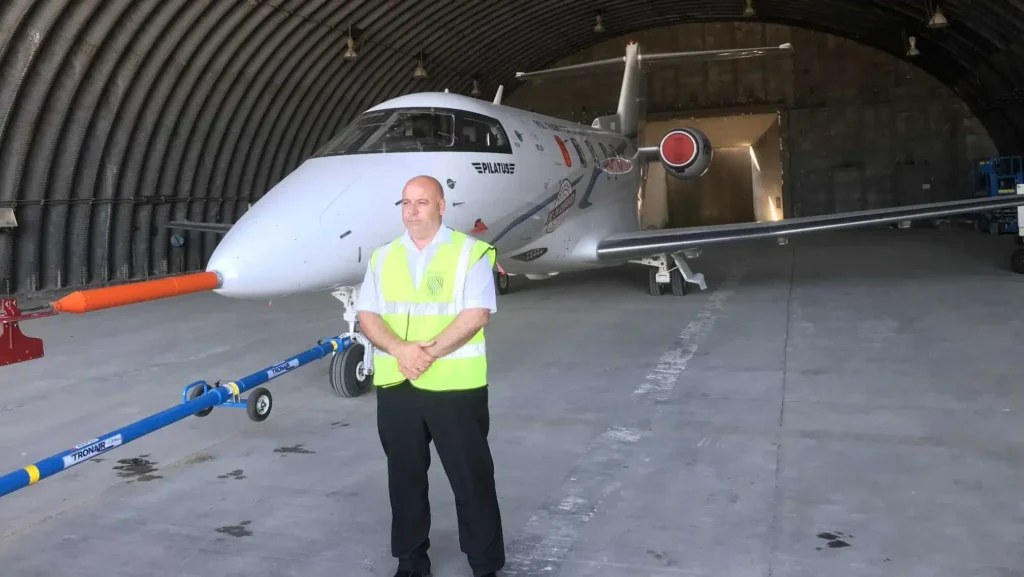 Security guard conducting penetration test inside aircraft hangar – MW Global Security site audits and risk assessments.