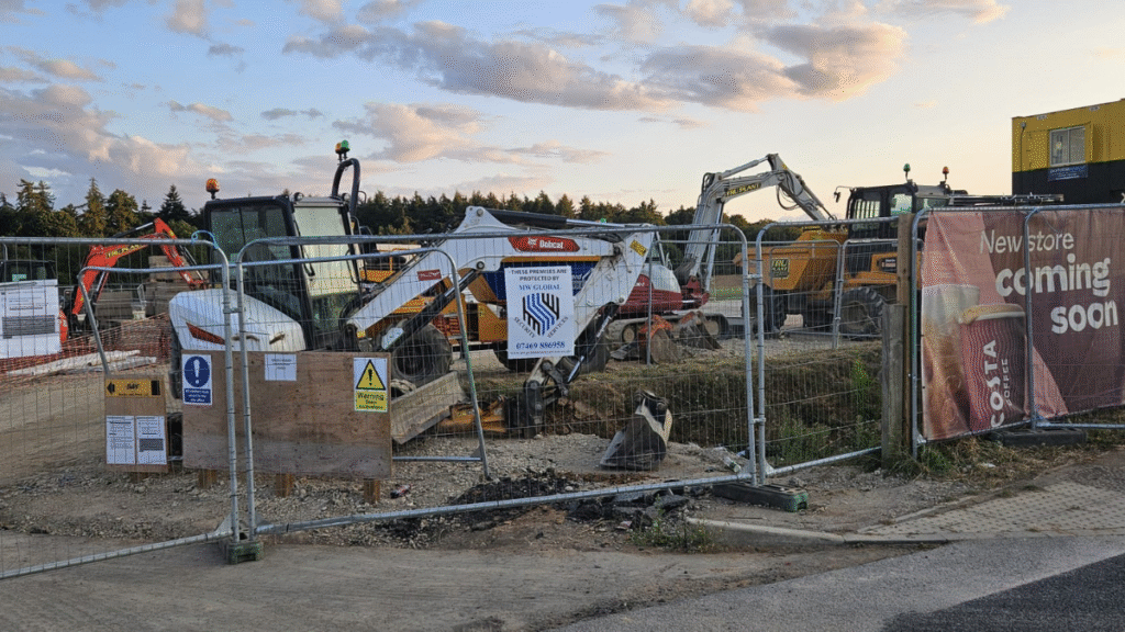 Construction site protected by MW Global Security, security signage on fence with machinery behind.